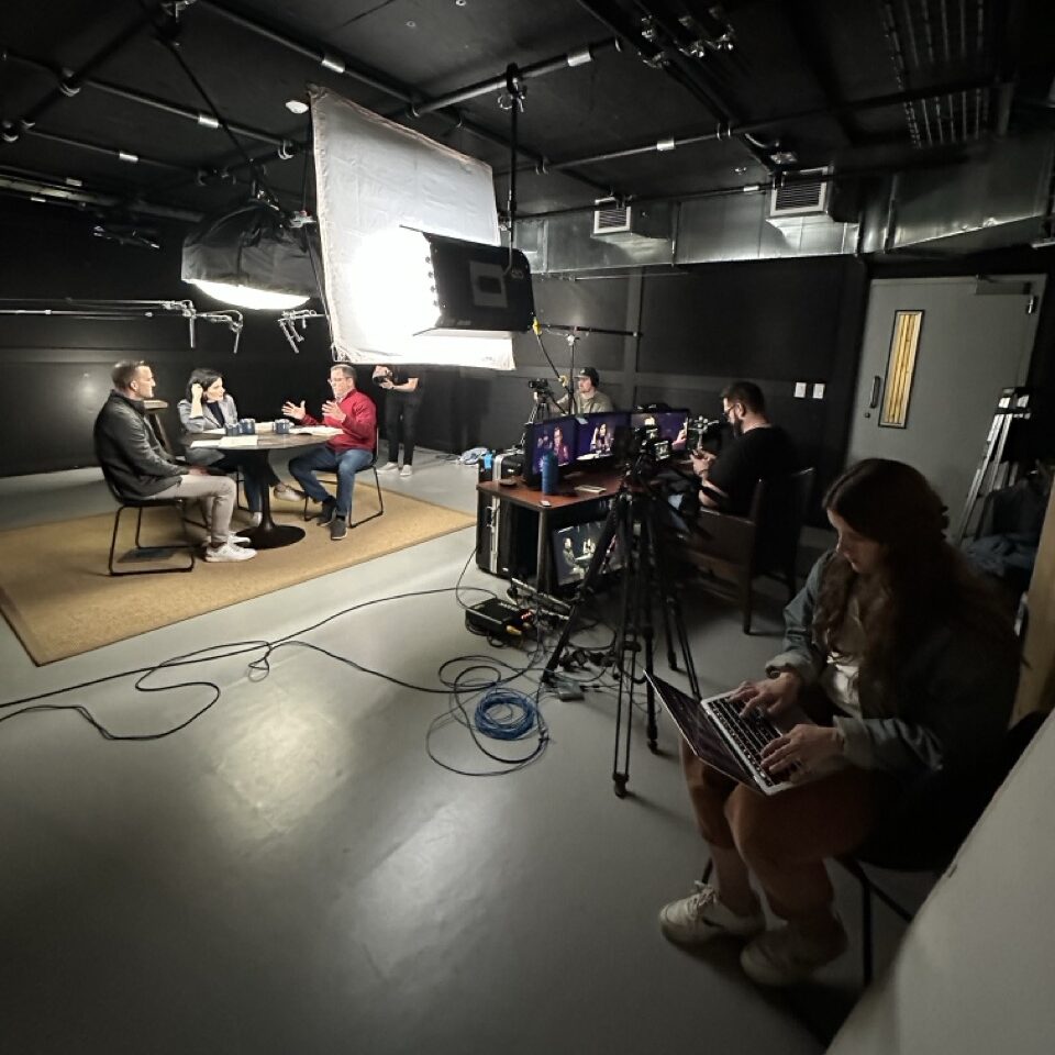 Chris Mano and crew recording a podcast on set